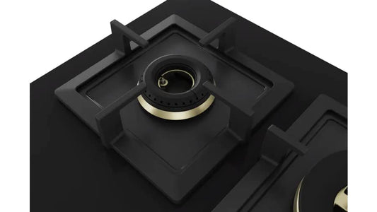 Black gas stove with gold trim on a white background